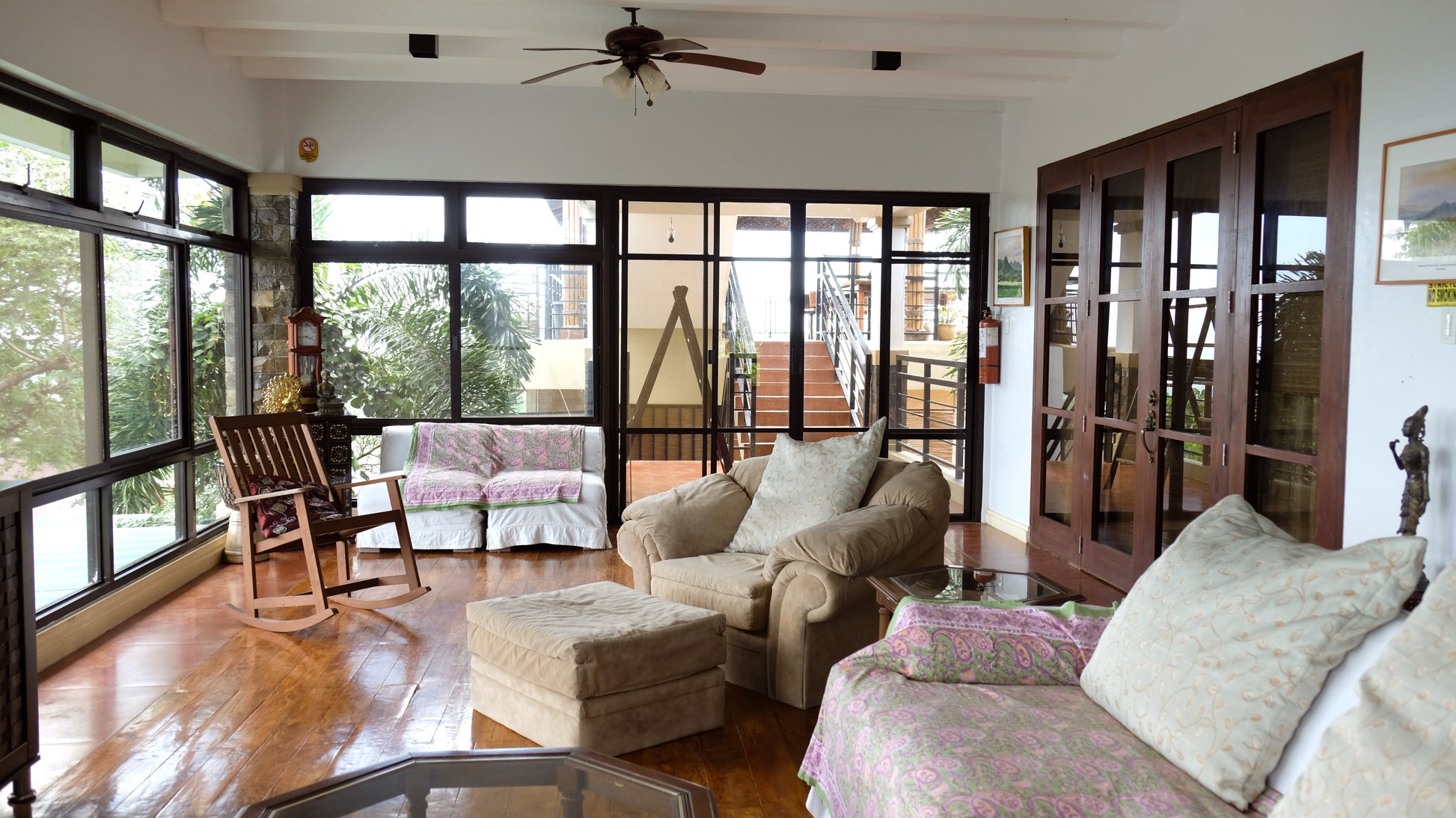 second floor living room with plush sofas and a rocking chair.